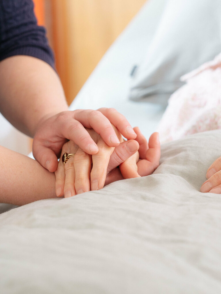 Eine Wundexpertin hält die Hand einer Patientin der Spezialisierten ambulanten Palliativversorgung in Ludwigshafen.